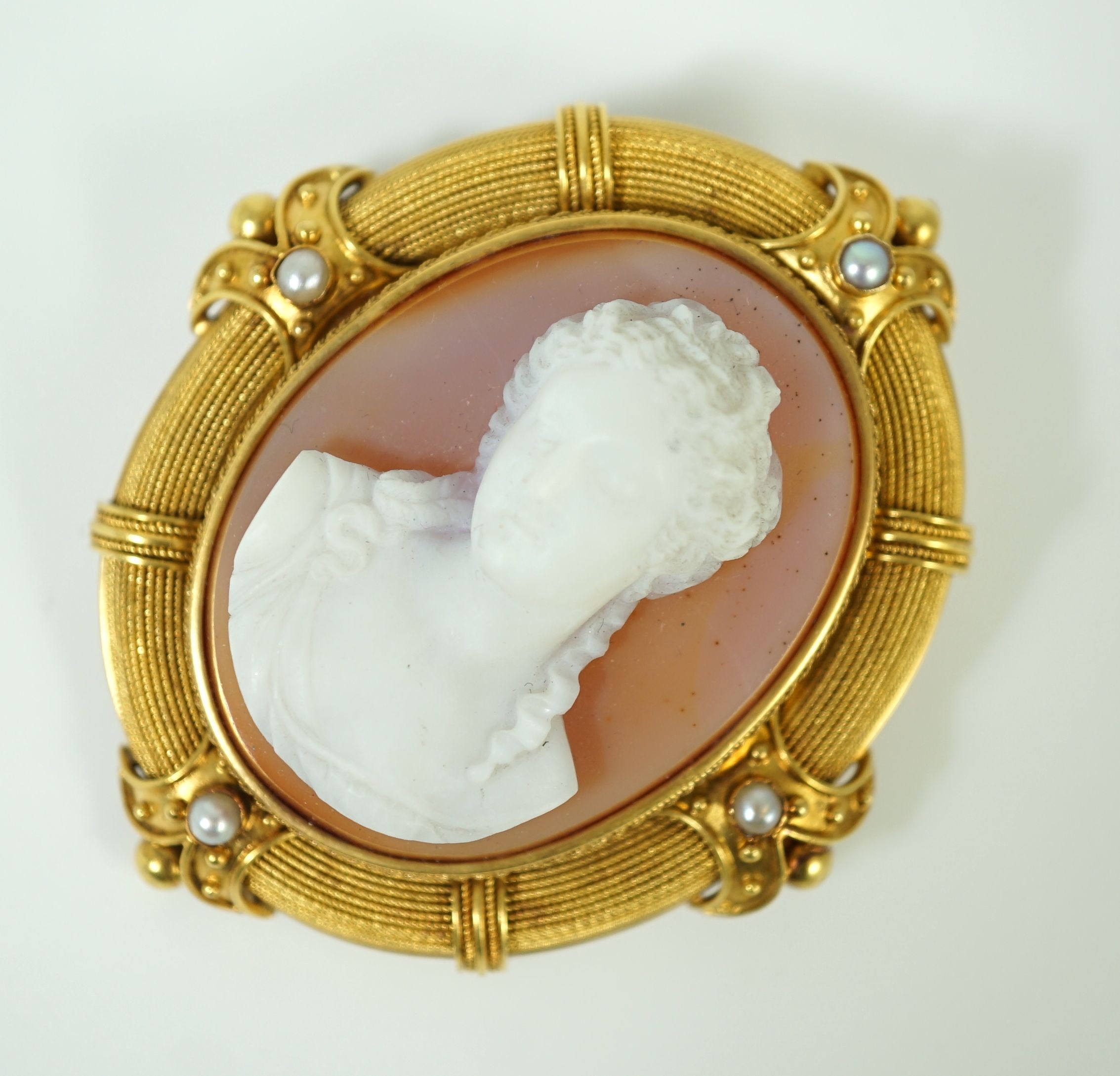 An early 20th century gold, sardonyx hardstone cameo and split pearl set oval brooch